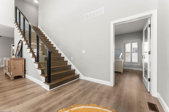 staircase with baseboards and wood finished floors