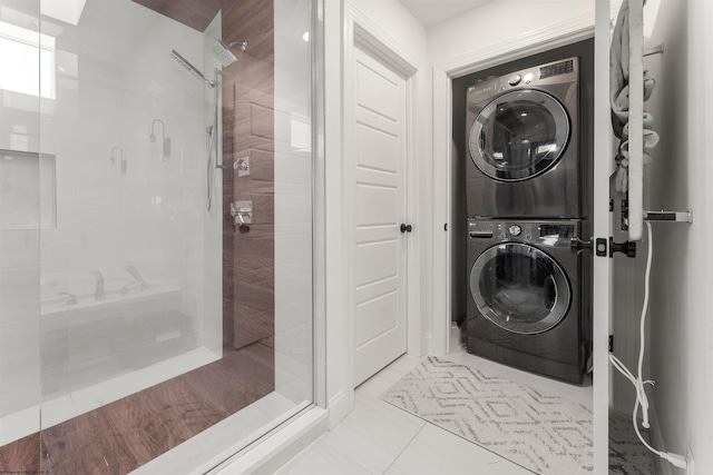 bathroom with stacked washer / drying machine and a shower stall