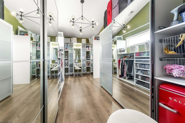 spacious closet featuring a chandelier and wood finished floors