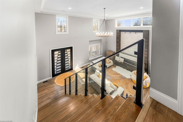 stairs with baseboards, wood finished floors, a chandelier, and recessed lighting