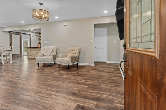 living area featuring a barn door, dark wood-type flooring, a chandelier, baseboards, and recessed lighting