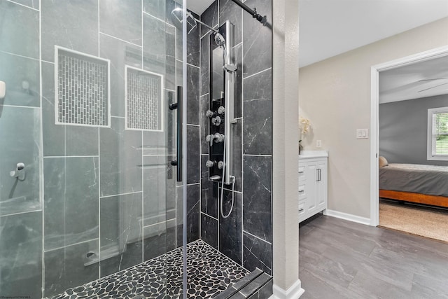 bathroom featuring ensuite bath, a stall shower, vanity, and baseboards