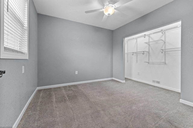 unfurnished bedroom featuring carpet flooring, baseboards, ceiling fan, and a closet