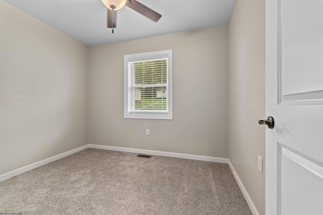 carpeted empty room featuring ceiling fan and baseboards