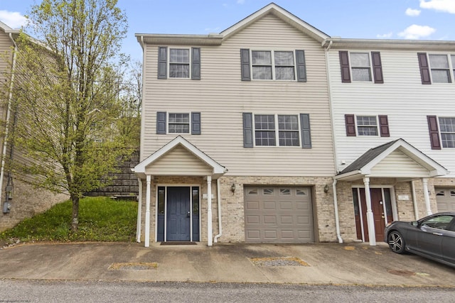 view of property featuring a garage and brick siding