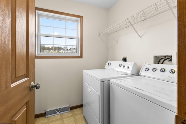 laundry area featuring washer and dryer, baseboards, and light flooring