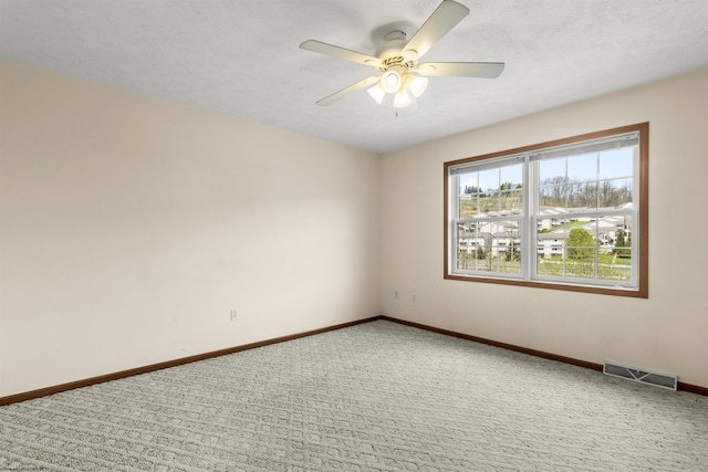 spare room with ceiling fan, carpet flooring, and baseboards