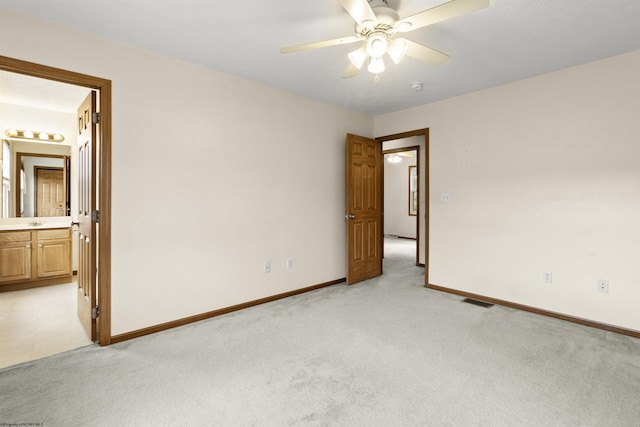 empty room with light colored carpet, baseboards, and a ceiling fan