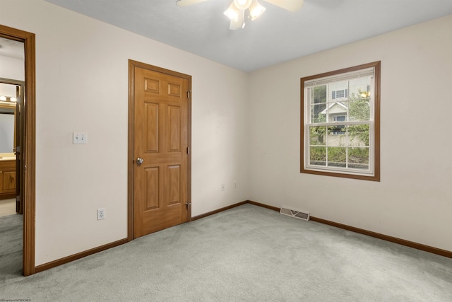 unfurnished room with light carpet, a ceiling fan, and baseboards