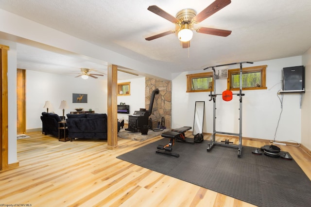 247 Daylily Ct, Terra Alta, WV 26764 - workout area with a wood stove, a ceiling fan, wood finished floors, and a textured ceiling