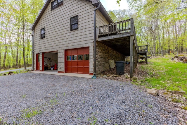 247 Daylily Ct, Terra Alta, WV 26764 - view of home's exterior with driveway, an attached garage, a wooden deck, and stone siding