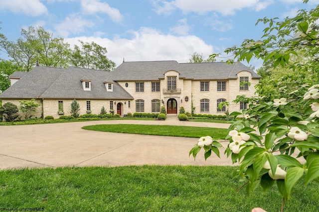 3906 Westlake Dr, Morgantown, WV 26508 - french provincial home featuring a front yard, stone siding, and curved driveway