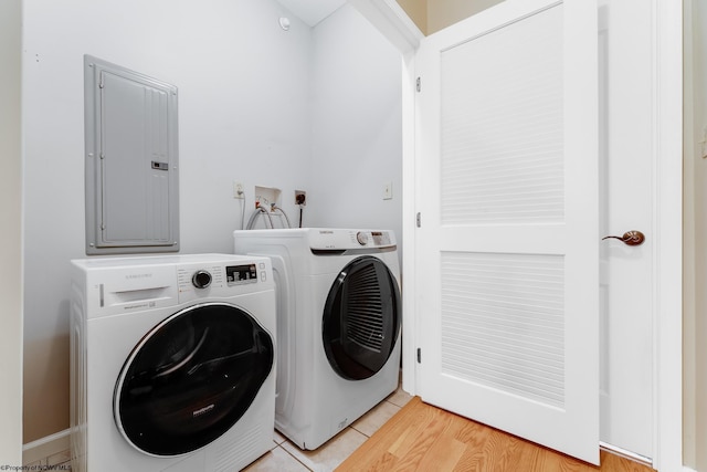 laundry room featuring electric panel and separate washer and dryer