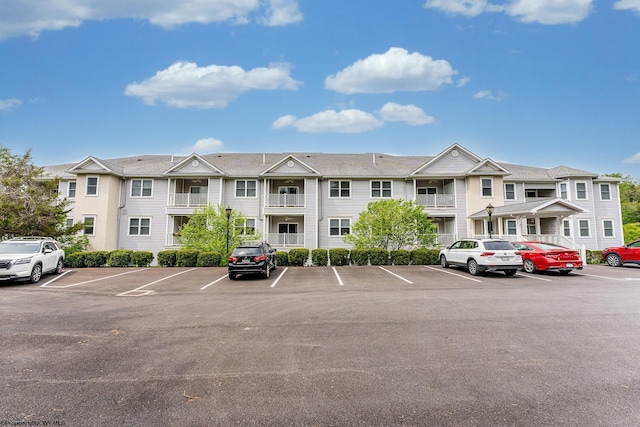 view of building exterior featuring uncovered parking and a residential view