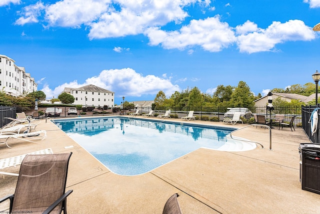 community pool with fence and a patio