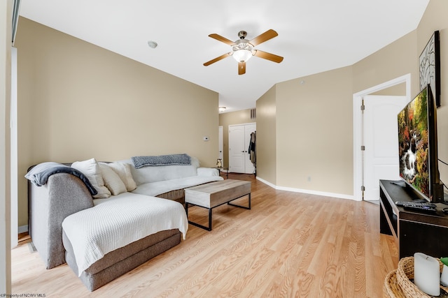 living area with a ceiling fan, light wood-type flooring, and baseboards