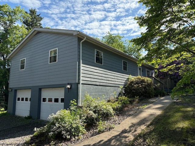 view of side of home featuring a garage and driveway