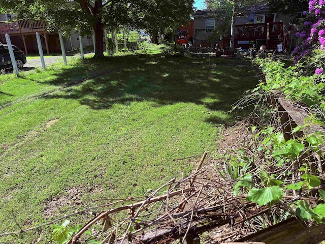 view of green lawn featuring a wooden deck
