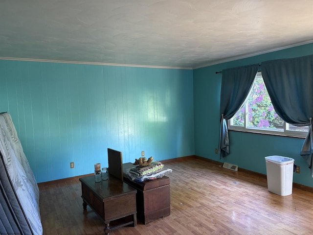 office space featuring wood finished floors, baseboards, and crown molding