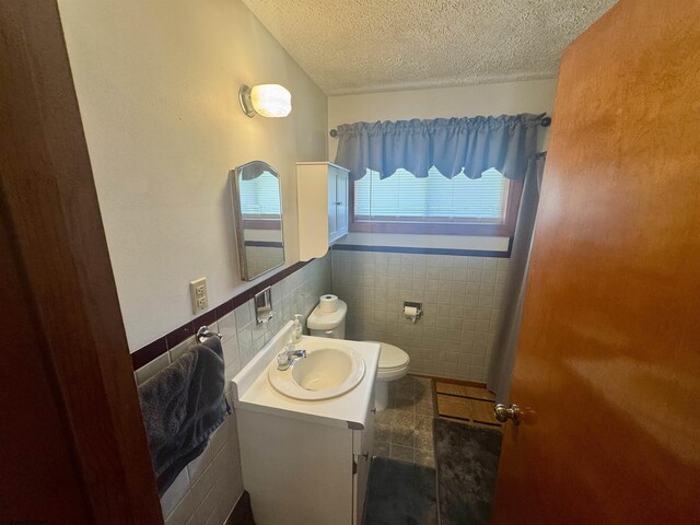 213 Albright Rd, Kingwood, WV 26537 - bathroom featuring a textured ceiling, tile walls, vanity, and toilet