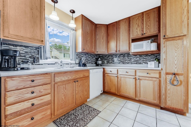 kitchen featuring white appliances, a sink, backsplash, and light tile patterned floors