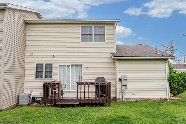 rear view of house featuring a deck, a yard, central AC, and a shingled roof