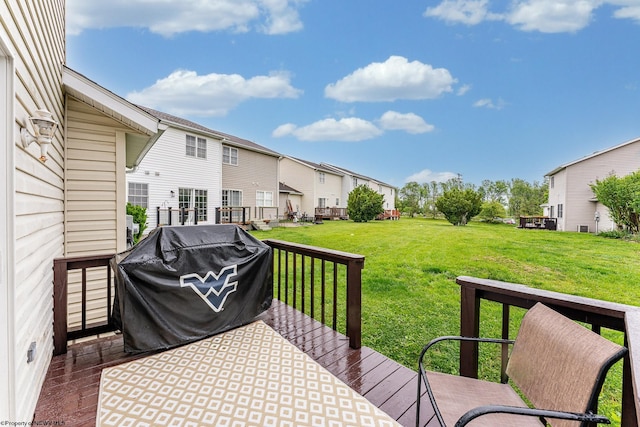 wooden terrace featuring grilling area, a residential view, and a lawn