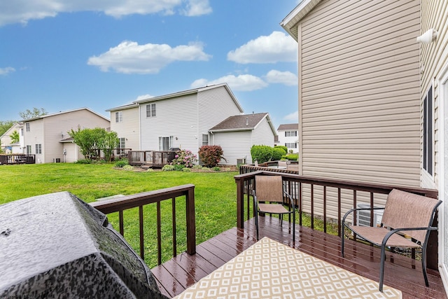 wooden terrace featuring a residential view and a lawn