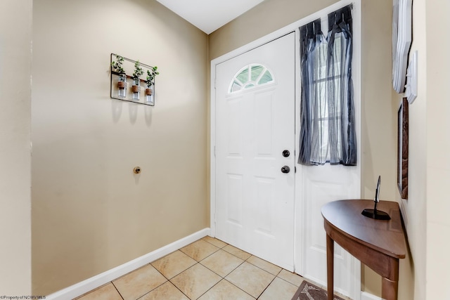 entryway with light tile patterned flooring and baseboards