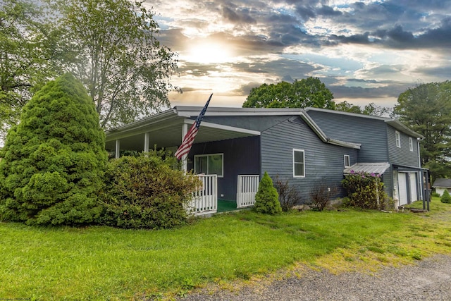 107 Orchard St, Masontown, WV 26542 - property exterior at dusk with covered porch, a lawn, and a garage