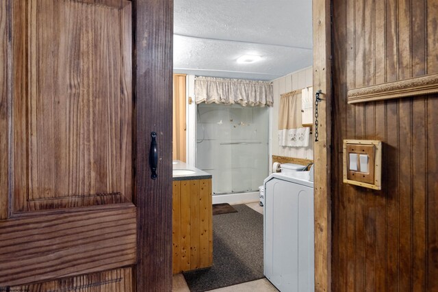 107 Orchard St, Masontown, WV 26542 - full bathroom with washer / clothes dryer, a stall shower, a textured ceiling, wood walls, and toilet