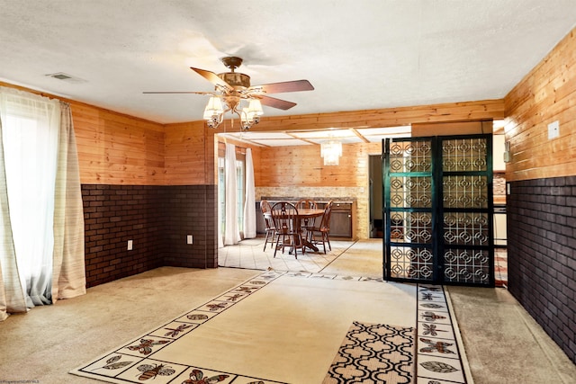107 Orchard St, Masontown, WV 26542 - kitchen featuring wooden walls, brick wall, a ceiling fan, french doors, and carpet flooring