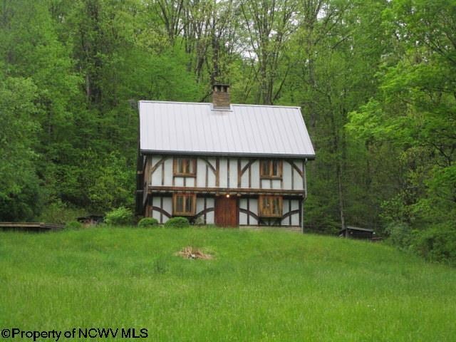 1303 Pheasant Mountain Rd, Kerens, WV 26276 - rear view of house featuring a view of trees, a chimney, and metal roof