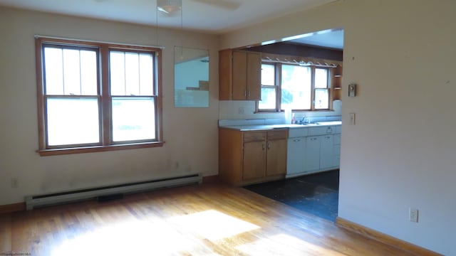 1782 Parsons Rd, Montrose, WV 26283 - kitchen featuring a baseboard heating unit, wood finished floors, a ceiling fan, light countertops, and decorative backsplash