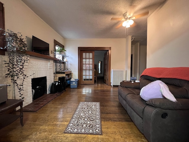 374 Forest Ave Unit 3, Morgantown, WV 26505 - living area with radiator, wood-type flooring, a fireplace, a ceiling fan, and a textured ceiling