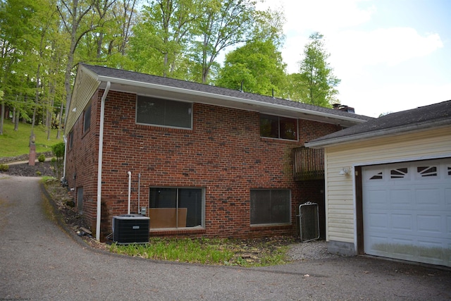 1251 Briercliff Rd, Bridgeport, WV 26330 - view of side of home with central AC unit, brick siding, asphalt driveway, and a garage