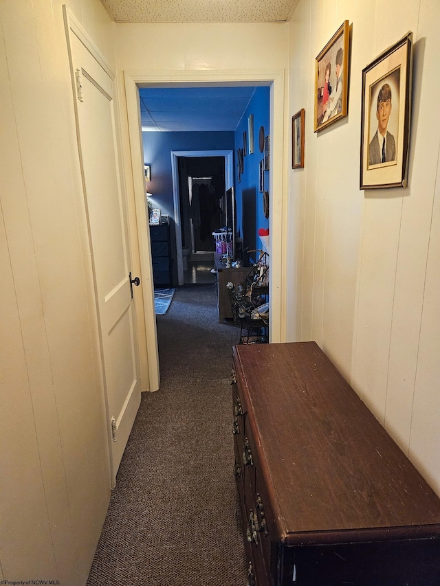 corridor featuring dark colored carpet