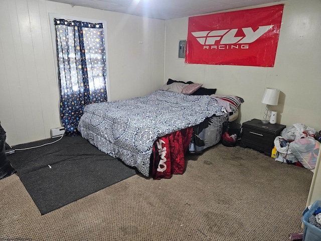 bedroom with carpet and wood walls