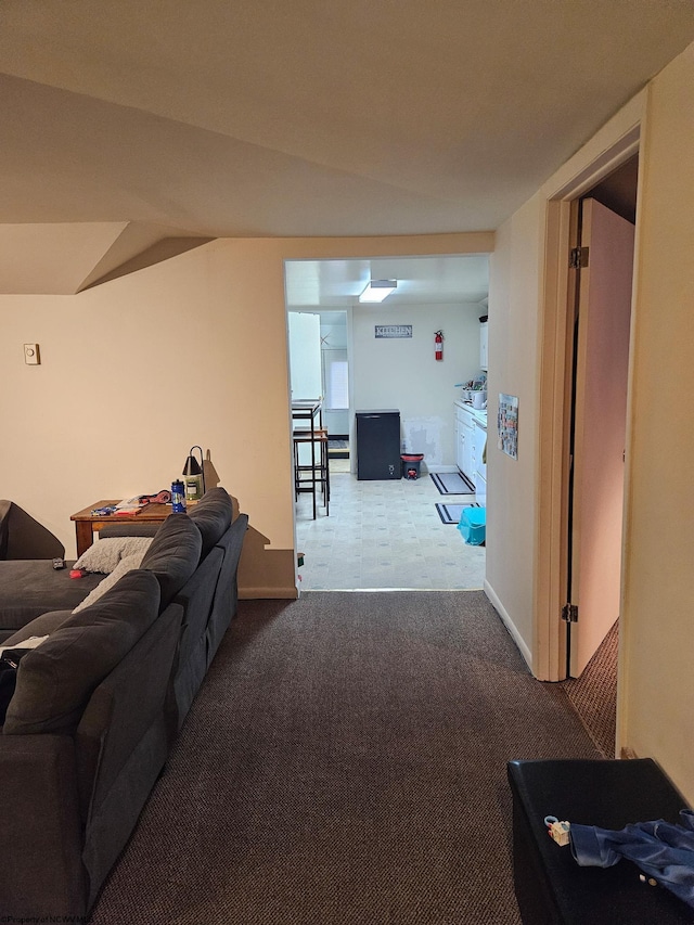 carpeted living area with tile patterned floors and baseboards