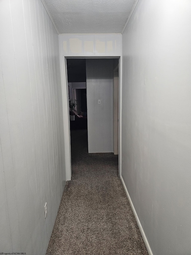 hallway featuring carpet, a textured ceiling, and ornamental molding