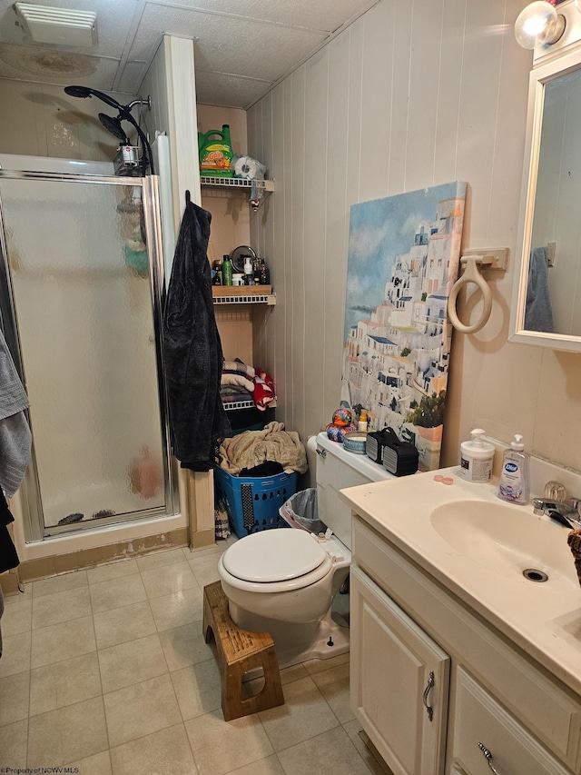 full bathroom featuring a stall shower, vanity, tile patterned flooring, and toilet
