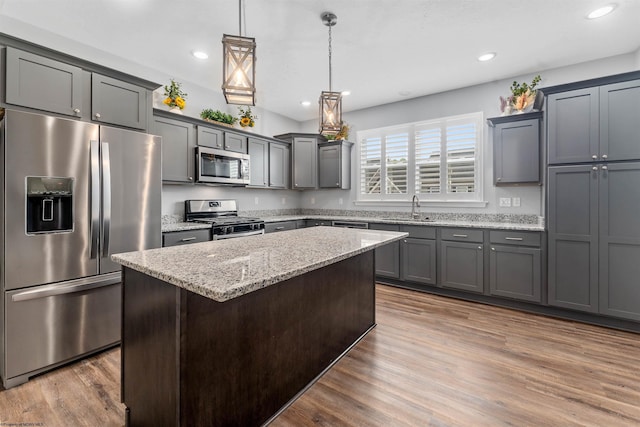 2052 Mountain Ash Ln, Morgantown, WV 26501 - kitchen featuring appliances with stainless steel finishes, a sink, light stone counters, a center island, and wood finished floors
