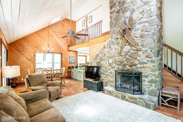434 Cabin Mountain Rd, Davis, WV 26260 - living area with wood finished floors, a chandelier, ceiling fan, wood walls, and a stone fireplace