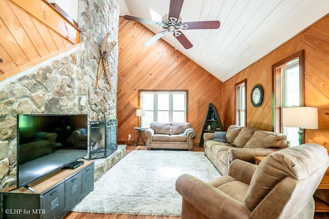 434 Cabin Mountain Rd, Davis, WV 26260 - living area with vaulted ceiling, a ceiling fan, wood finished floors, wood walls, and a stone fireplace