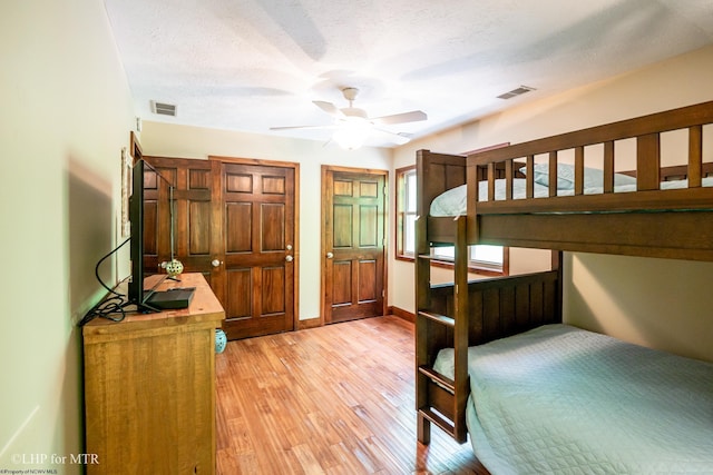 434 Cabin Mountain Rd, Davis, WV 26260 - unfurnished bedroom with light wood finished floors, multiple closets, baseboards, a textured ceiling, and ceiling fan
