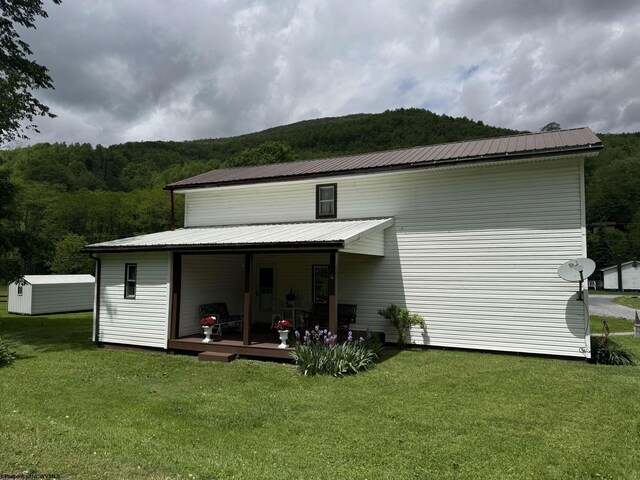 19 Gandy Dr, Dryfork, WV 26263 - rear view of property with a lawn, metal roof, a view of trees, and an outbuilding