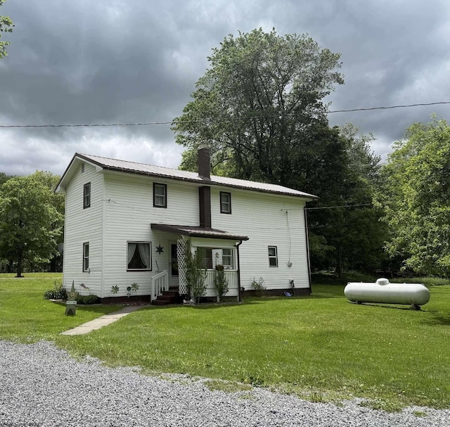 19 Gandy Dr, Dryfork, WV 26263 - rear view of house featuring covered porch, a lawn, metal roof, and a chimney