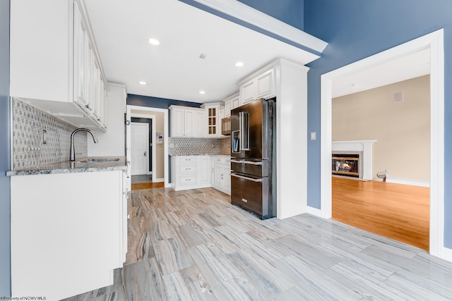 2022 Georgian Ln, Morgantown, WV 26508 - kitchen featuring high end refrigerator, a sink, light stone countertops, a glass covered fireplace, and tasteful backsplash