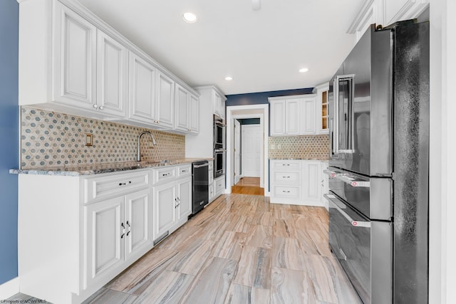 2022 Georgian Ln, Morgantown, WV 26508 - kitchen featuring appliances with stainless steel finishes, a sink, white cabinetry, light stone counters, and backsplash