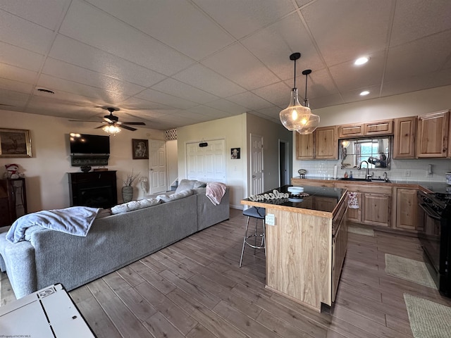 717 Lakeview Dr, Horner, WV 26372 - kitchen featuring black gas stove, a center island, a ceiling fan, a breakfast bar, and wood finished floors
